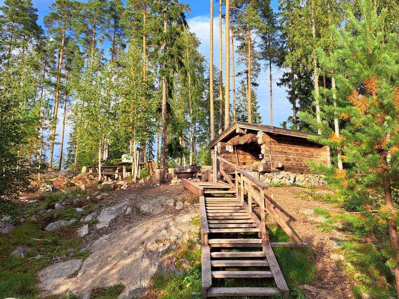Hirsilaavu kalliolla, puuportaat nousevat laavulle mäntyjen keskellä